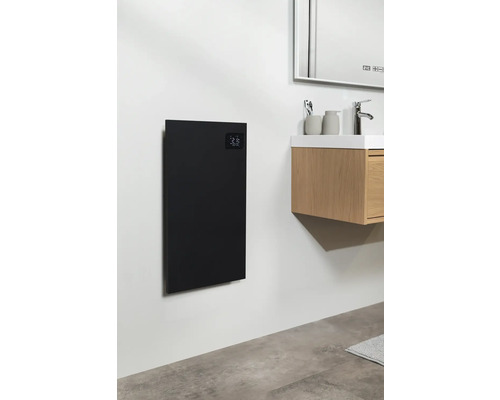 Badezimmer mit einem schwarzen Heizpaneel an der Wand neben einem Waschtisch