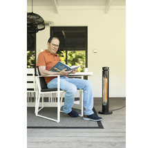 Mann liest Buch auf Terrasse mit Heizstrahler