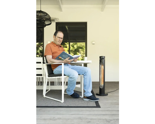 Mann liest Buch auf Terrasse mit Heizstrahler