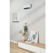 Wandmontierter Heizlüfter über Sideboard mit Dekoration und Bildern.