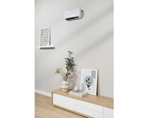 Wandmontierter Heizlüfter über Sideboard mit Dekoration und Bildern.