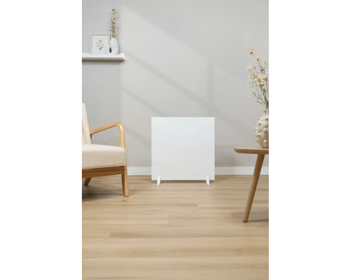 Weißer Heizkörper im Wohnzimmer mit Sessel und Tisch