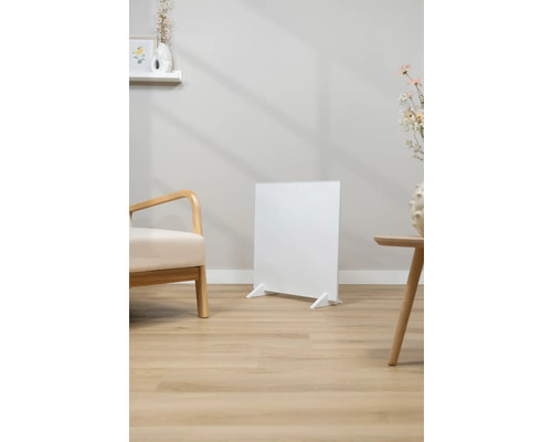 Weißer Infrarotheizkörper steht in einem hellen Wohnraum.