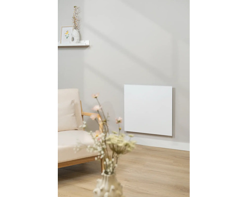 Wohnzimmer mit einem Infrarotheizkörper an der Wand neben einem Sessel