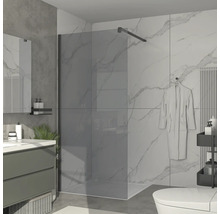 Badezimmer mit Duschabtrennung aus Glas, Waschtisch und Toilette.