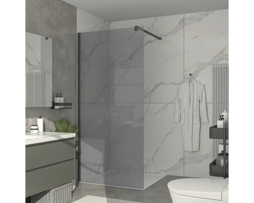 Badezimmer mit Duschabtrennung aus Glas, Waschtisch und Toilette.