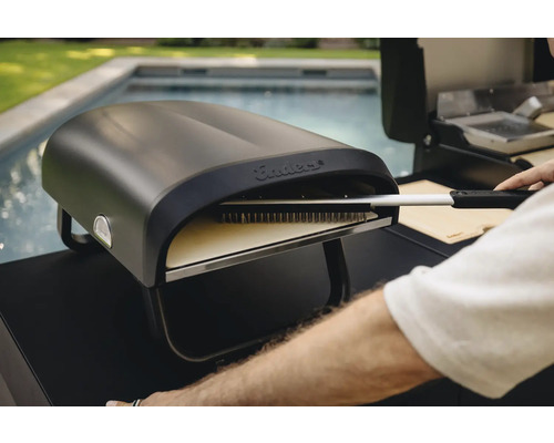 Enders Pizzaofen mit Pizzabürste in der Nähe eines Pools