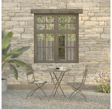 Gartenszene mit Tisch und zwei Stühlen vor einer Steinwand