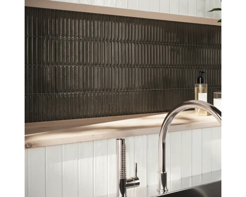 Wandgestaltung mit länglichen, dunklen Fliesen und Armatur