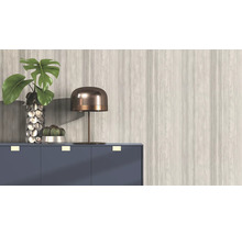 Dekoratives Interieur mit Pflanze, Lampe und Kommode vor einer gemusterten Wand