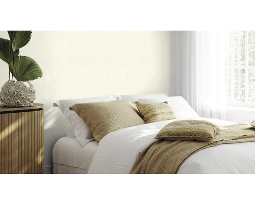 Schlafzimmer mit Bett, Nachttisch und Zimmerpflanze