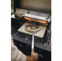 Pizza auf Pizzaschieber im Grill