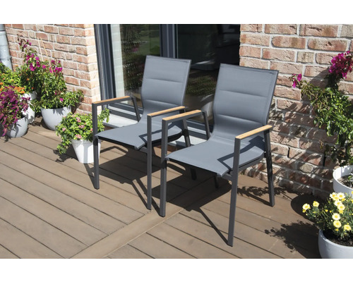 Zwei graue Gartenstühle mit Armlehnen aus Holz auf einer Terrasse.