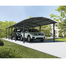 Zwei Autos parken unter einem Carport auf einer gepflasterten Auffahrt vor einem Wohnhaus.