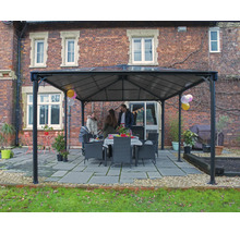 Gartenpavillon mit Familie und Esstisch im Freien vor Backsteingebäude