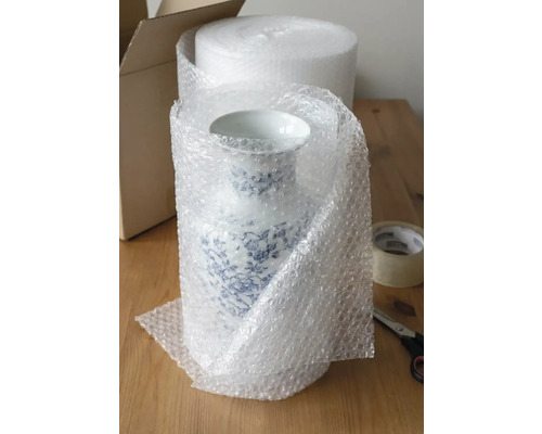 Eine Porzellanvase mit blauem Blumendekor ist zum Transport mit Luftpolsterfolie verpackt.