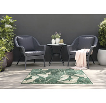 Gartenszene mit zwei Rattansesseln, kleinem Tisch und einem grünen Teppich mit Blattmuster