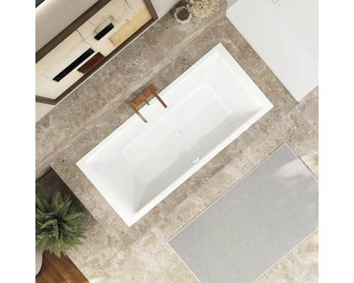 Aufnahme von oben einer rechteckigen Badewanne, Armaturen, Badteppich und Deko in einem Badezimmer.