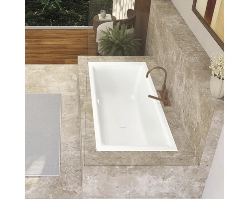 Badezimmer mit eingelassener Badewanne, Armatur und Marmorfliesen