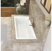 Aufnahme von oben einer Badewanne in einem Badezimmer mit Marmorfliesen und Armatur.