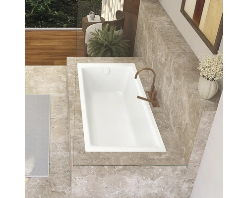 Aufnahme von oben einer Badewanne in einem Badezimmer mit Marmorfliesen und Armatur.