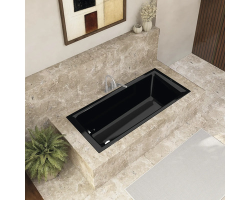 Eingebaute schwarze Badewanne in einem Badezimmer mit Marmorfliesen und Kunstwerk an der Wand
