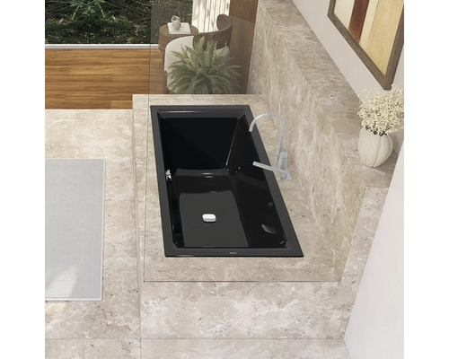 Schwarze Badewanne mit Armatur in einem Badezimmer mit Fliesenboden.