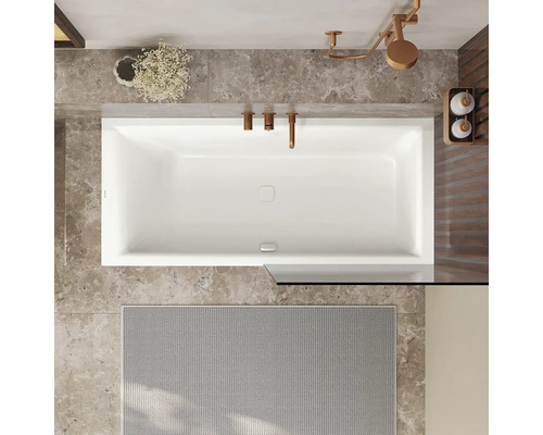 Aufsicht auf ein Badezimmer mit rechteckiger Badewanne, Armaturen und Badematte