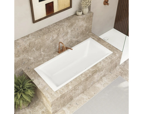 Modernes Badezimmer mit eingelassener Badewanne, Marmorverkleidung und stilvoller Armatur.