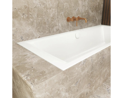 Eingebaute Badewanne mit Armatur an Marmorwand