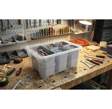 Transparente Aufbewahrungsbox mit Fächern zur Werkzeugorganisation auf einer Werkbank.