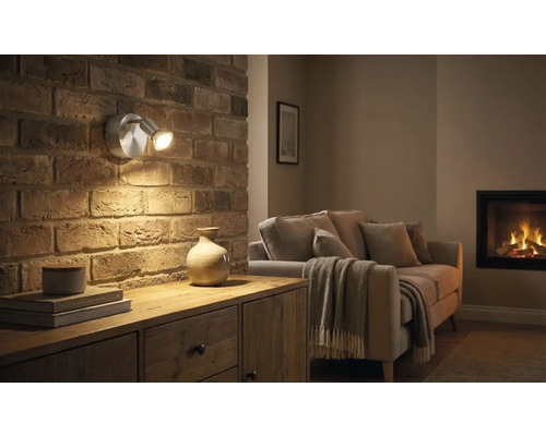 Wohnzimmer mit gemauerter Wand, Kommode und Zwei-Flammen-Wandleuchte