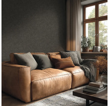 Wohnzimmer mit Ledersofa, Kissen und Couchtisch