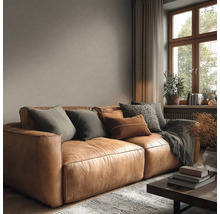 Wohnzimmer mit Ledersofa, Kissen und Dekoration