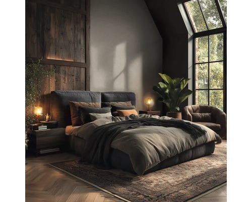 Schlafzimmer mit Doppelbett, Nachttischen, Lampen, Sessel, Zimmerpflanze und Teppich.