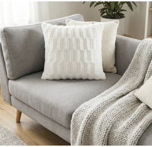 Graues Sofa mit Kissen und Strickdecke