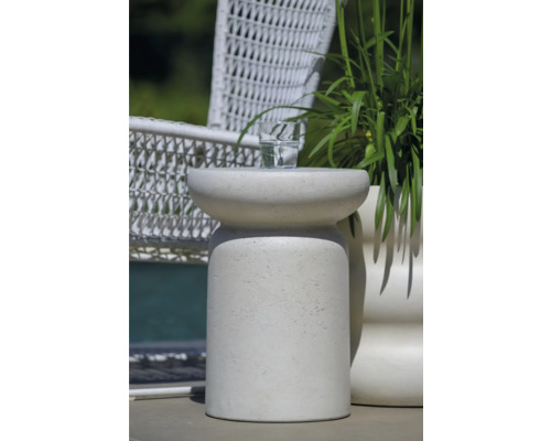 Dekorativer Beistelltisch aus Stein mit Getränk und Pflanze