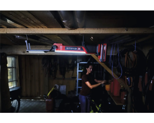 Einhell Logo Akku-Lampe im Werkstattbereich mit einer Person im Hintergrund