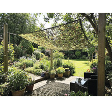 Garten mit Tarnnetz als Sonnenschutz über einer Sitzecke
