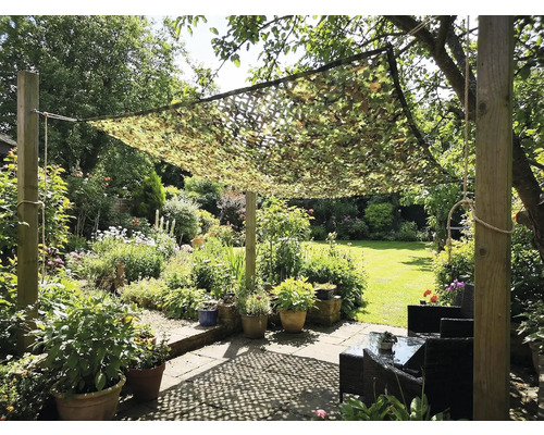 Garten mit Tarnnetz als Sonnenschutz über einer Sitzecke