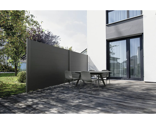 Sichtschutzzaun und Gartentisch mit Stühlen auf einer Terrasse