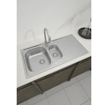 Spüle aus Edelstahl mit Abtropffläche und Wasserhahn auf einer Arbeitsplatte