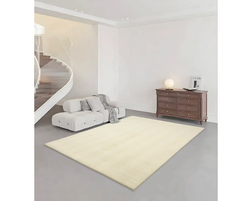 Wohnraum mit beigem Teppich, Sofa, Kommode und Wendeltreppe