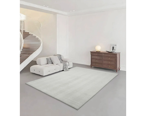 Innenraum mit Treppe, Sofa, Kommode und Teppich.