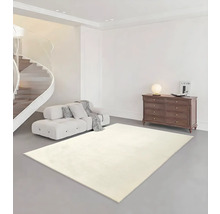 Helles Wohnzimmer mit hellem Teppich, Sofa, Kommode und Wendeltreppe.