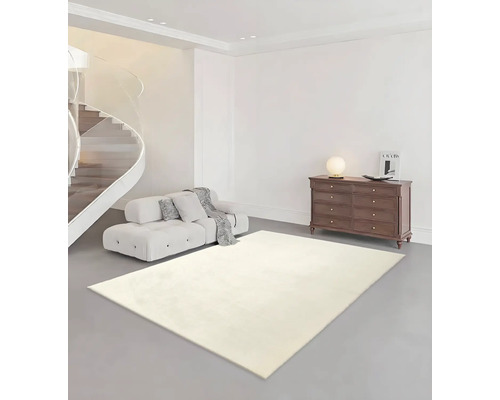 Helles Wohnzimmer mit hellem Teppich, Sofa, Kommode und Wendeltreppe.