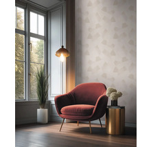 Wohnzimmer mit Sessel, Lampe und Zimmerpflanze vor einem Fenster