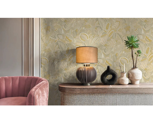 Innenraum mit floral gemusterter Tapete, Tischleuchte, Dekoration und rosa Sessel