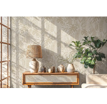 Wohnzimmer mit botanischer Tapete, Lampe, Dekoration und Pflanze auf einem Holzschrank.