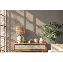 Dekoratives Wohnzimmer mit Lampe, Pflanzen und Kommode